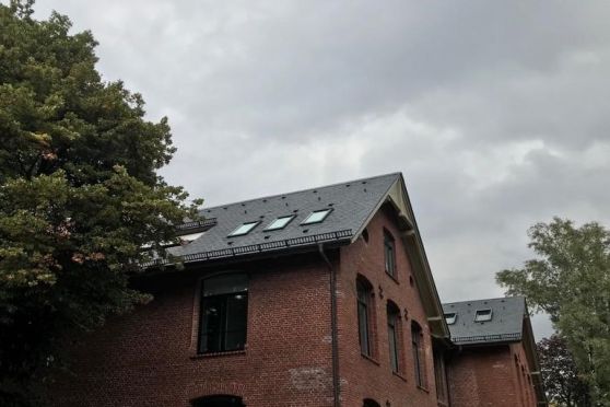 Dacheindeckung einer Schule mit Naturschieferplatten, Denkmalschutz.